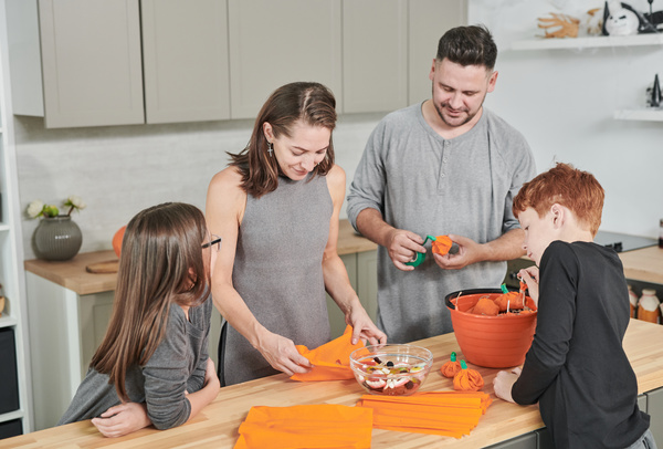 Parents Make Halloween Paper Pumpkins for Decoration and Their Children Look at It
